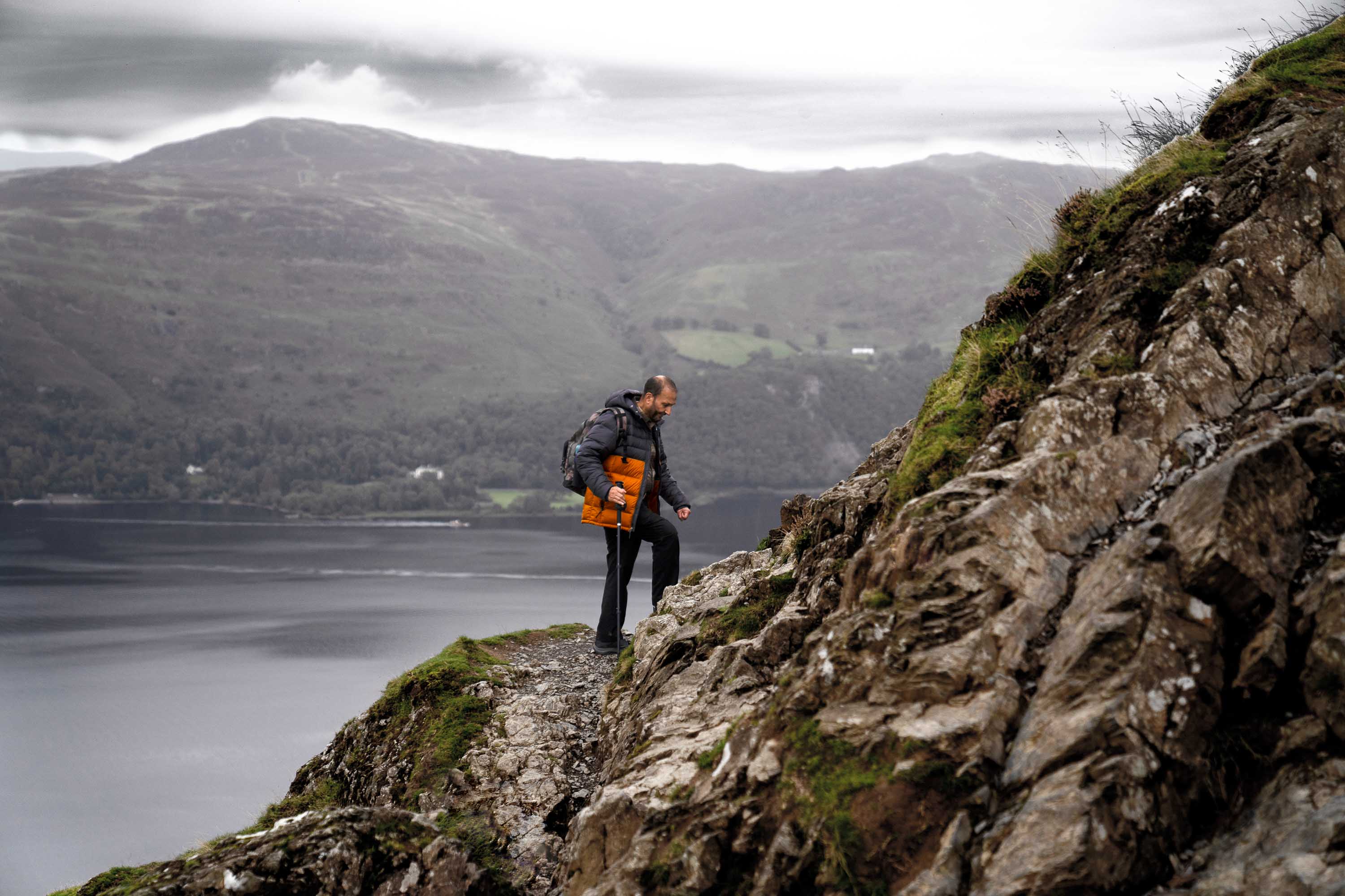 one of the members of boots and beards climbs a rocky cliff face