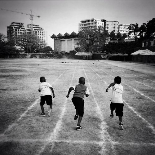 Three boys from the junior school at Aga Khan Academy in Mombasa, Kenya, race on the schoolÕs track prior to the morning school assembly.