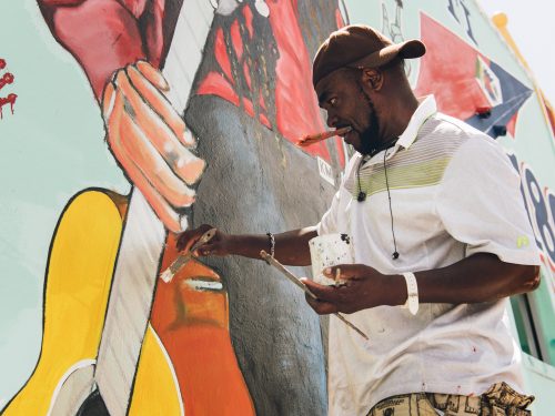 Serge Toussant paints one of his murals in Little Haiti, Miami, FL.
