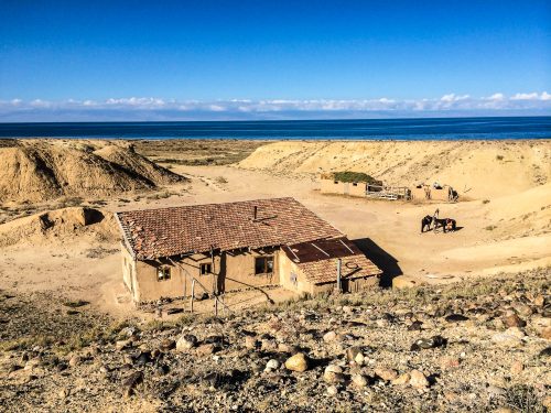 A house surrounded by the barren landscape of Kyrgyzstan