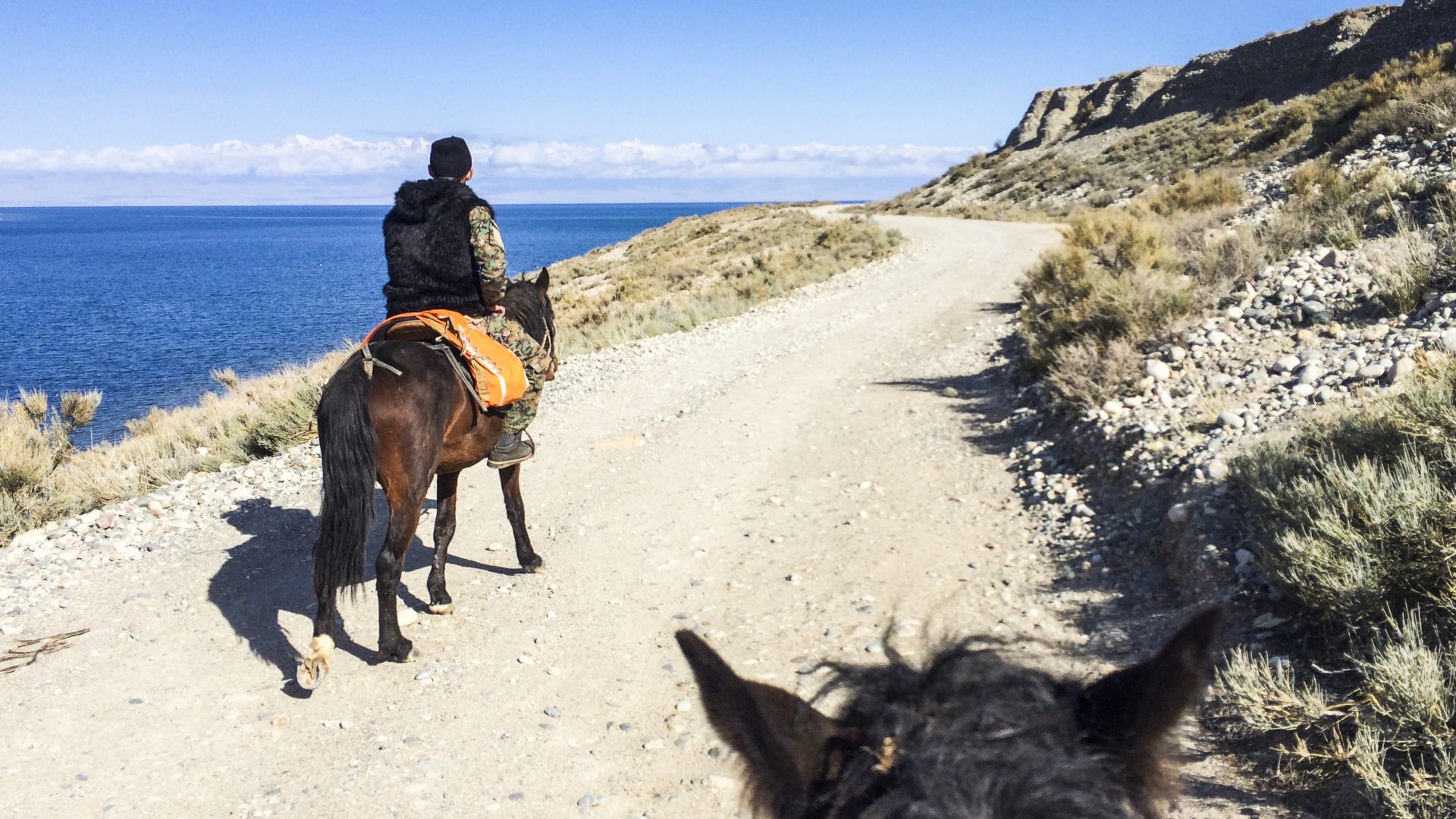 Horseriding along a dusty dirt road in Kyrgyzstan
