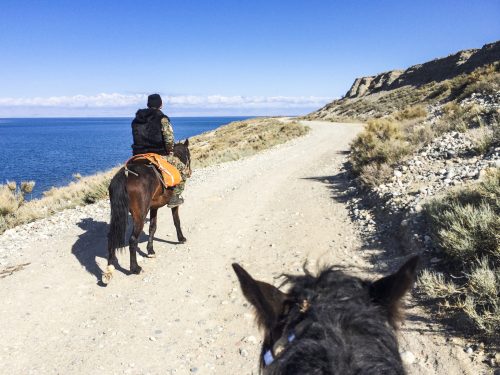 Horseriding along a dusty dirt road in Kyrgyzstan