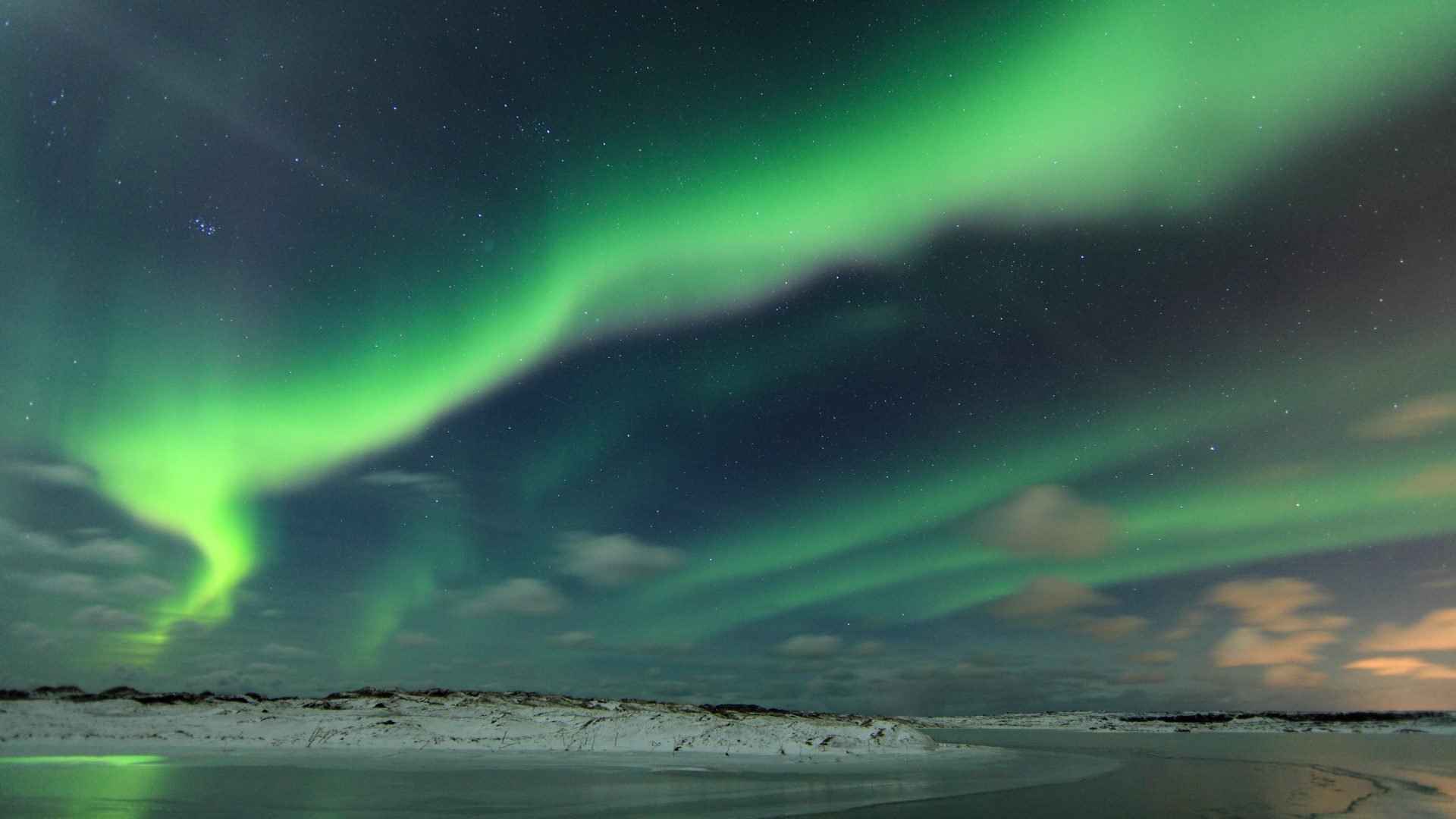 The Northern Lights over the Icelandic coastline.