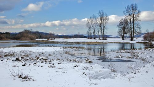 Lake Cerknica in Slovenia, when viewed with water in it and surrounded by snow.