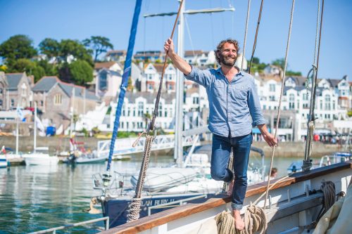 Travel writer James Stewart pictured on the Grayhound, a Cornish Lugger, in Brixham Marina, South Devon