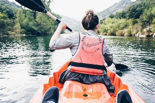 Rosie's back is visible as she kayaks down the river in Vallée de l'Hérault; kayaking in France