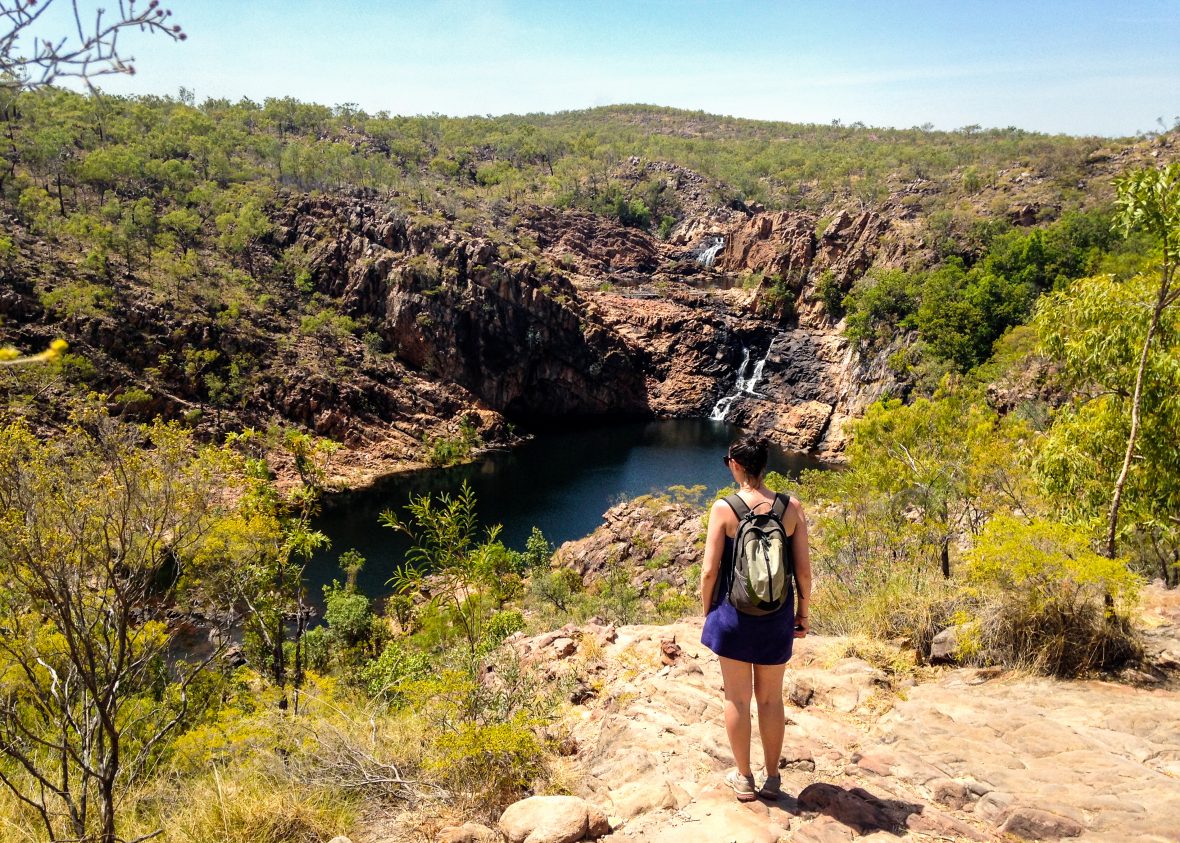 A woman looks out over a water hole in Australia.
