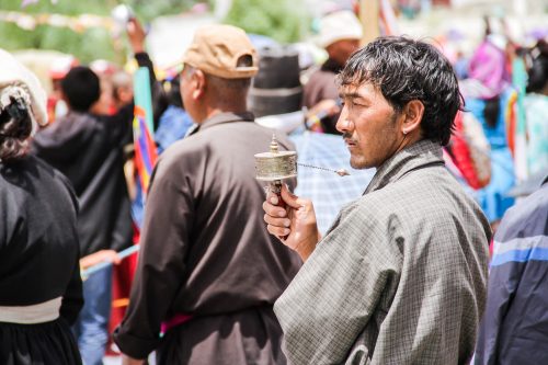 A man spins his personal prayer wheel at the Buddhist festival in Ladakh in the Himalayas