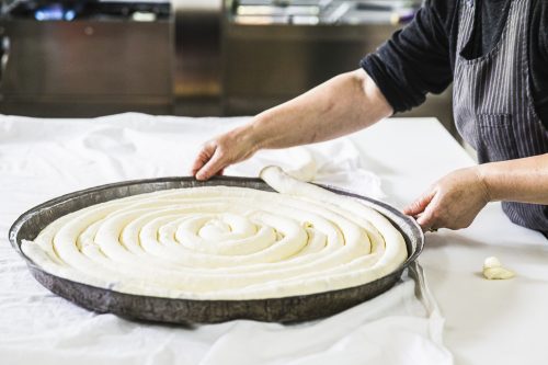 A womans hands can be seen preparing pita pie