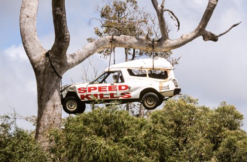 A smashed up car hanging from a tree in outback Australia warns drivers that speed kills.