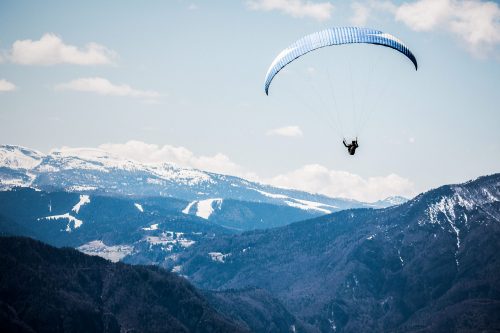 paraglider flies over the hills of Levico, Italy