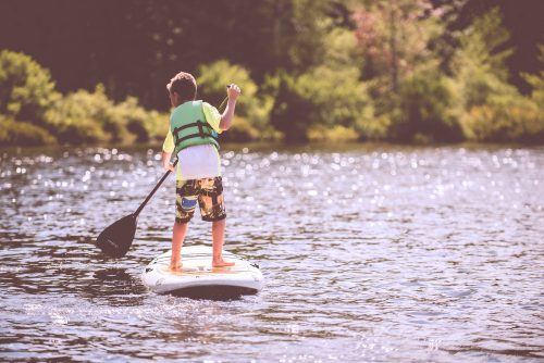 A young boy paddle boarding