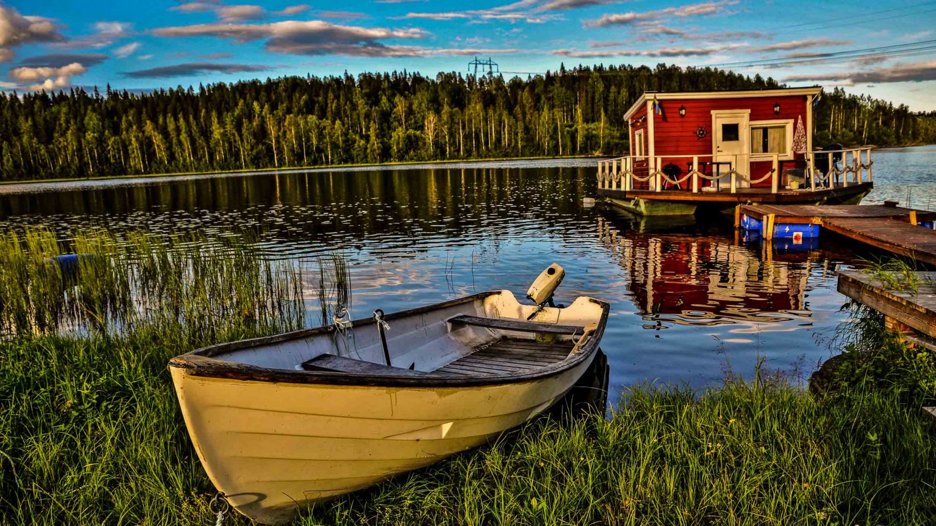 Floating cottage (stuga) and rowboat in Northern Sweden.