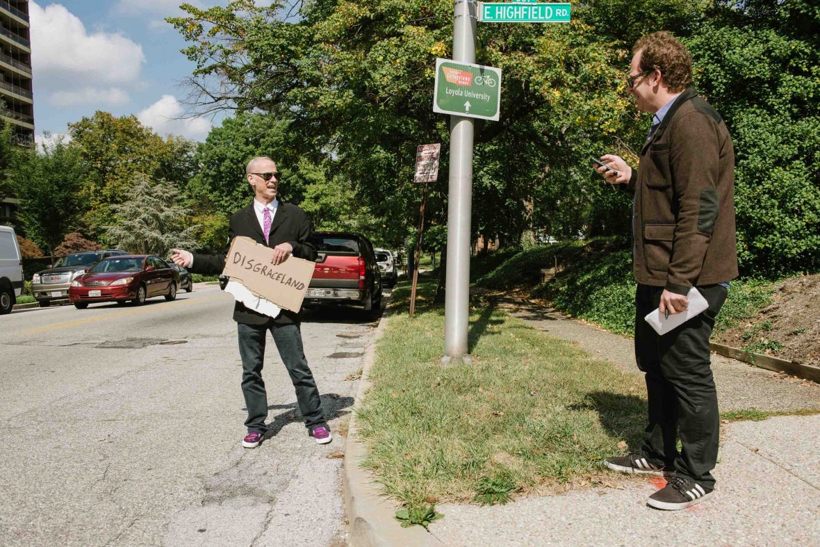 John Waters and travel writer, David Farley, hitchhike in Baltimore, MD.