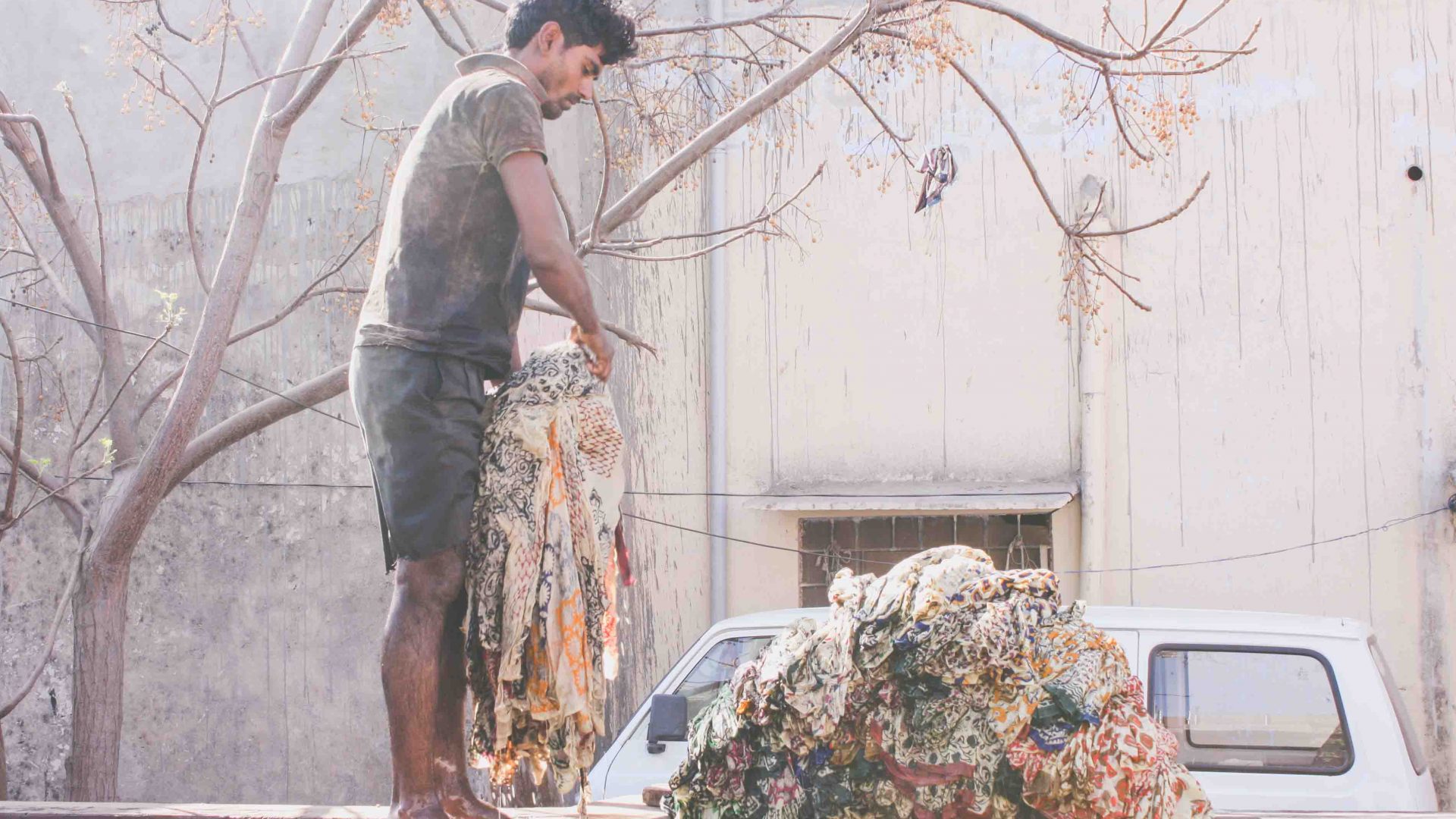 A local dobhi/washer rinses fabrics at Bagru's washing compound in Rajasthan, India.