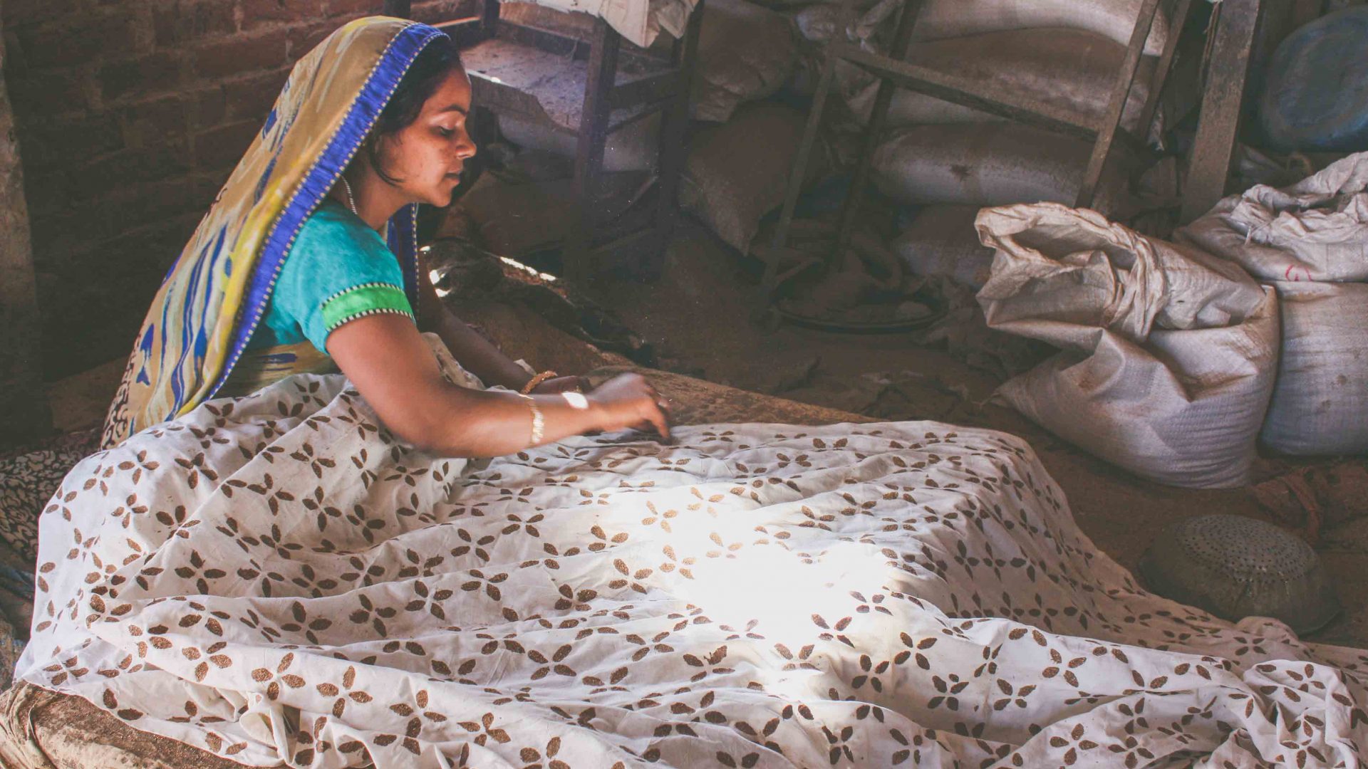 A woman in Bagru prepares textiles which are being printed with traditional blocks in Rajasthan, India.