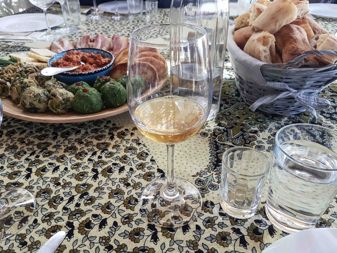 A glass of wine and a spread of local food at Iago's Winery, Georgia.