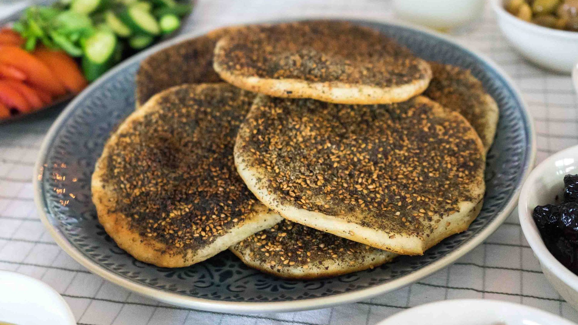 Zaatar bread, a type of pita bread topped with oregano, thyme, sumac, sesame seeds and salt mixed with olive oil, and then baked.