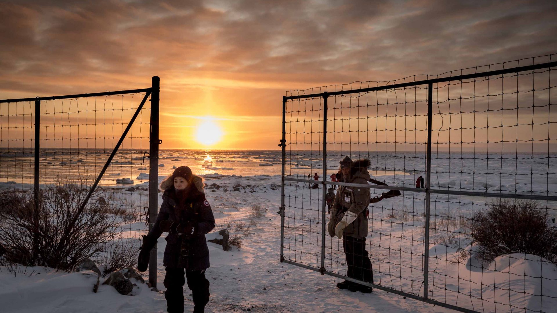 A guest enters Seal River Lodge’s gated compound after photographing the sunrise in Hudson Bay, Manitoba, Canada.