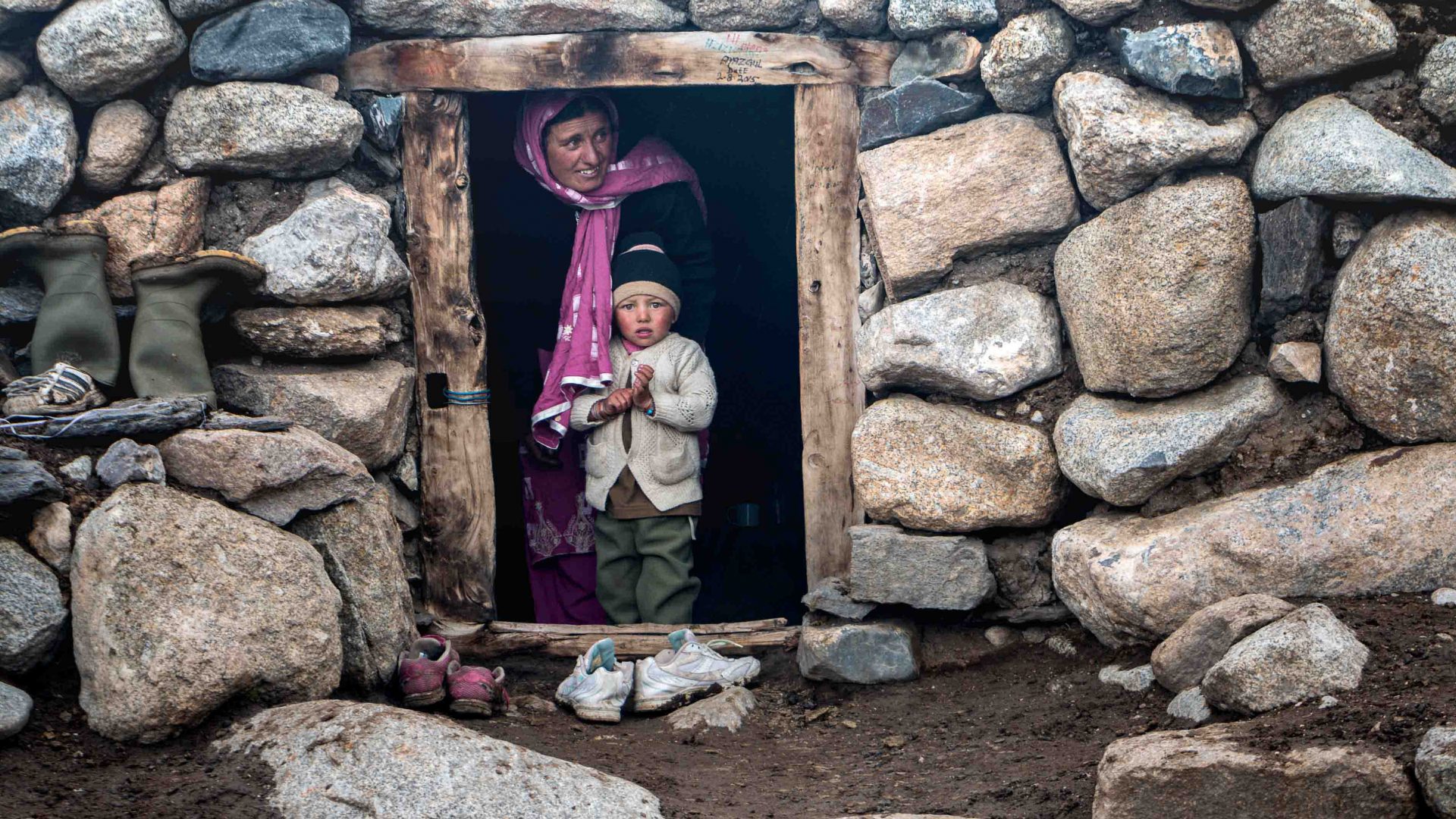 A Wakhi shepherdess in her hut with her child.