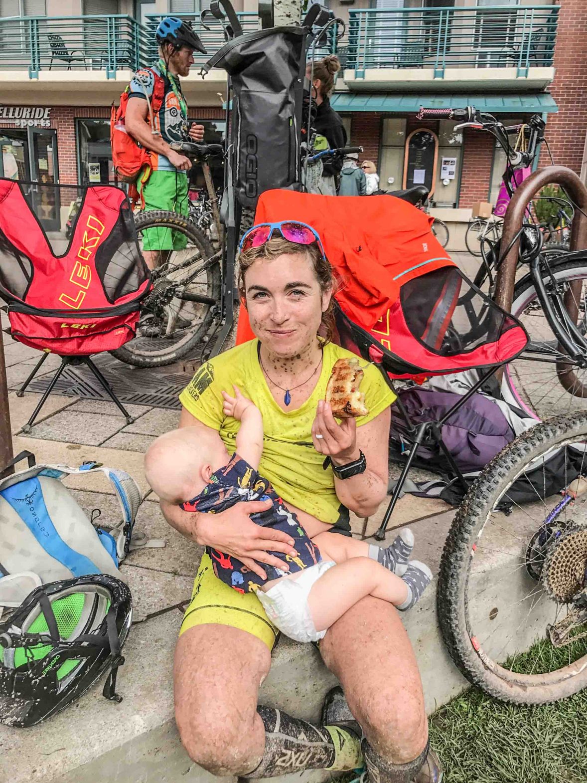Chelsey Magness breastfeeding her baby having just completed a very dirty ride.