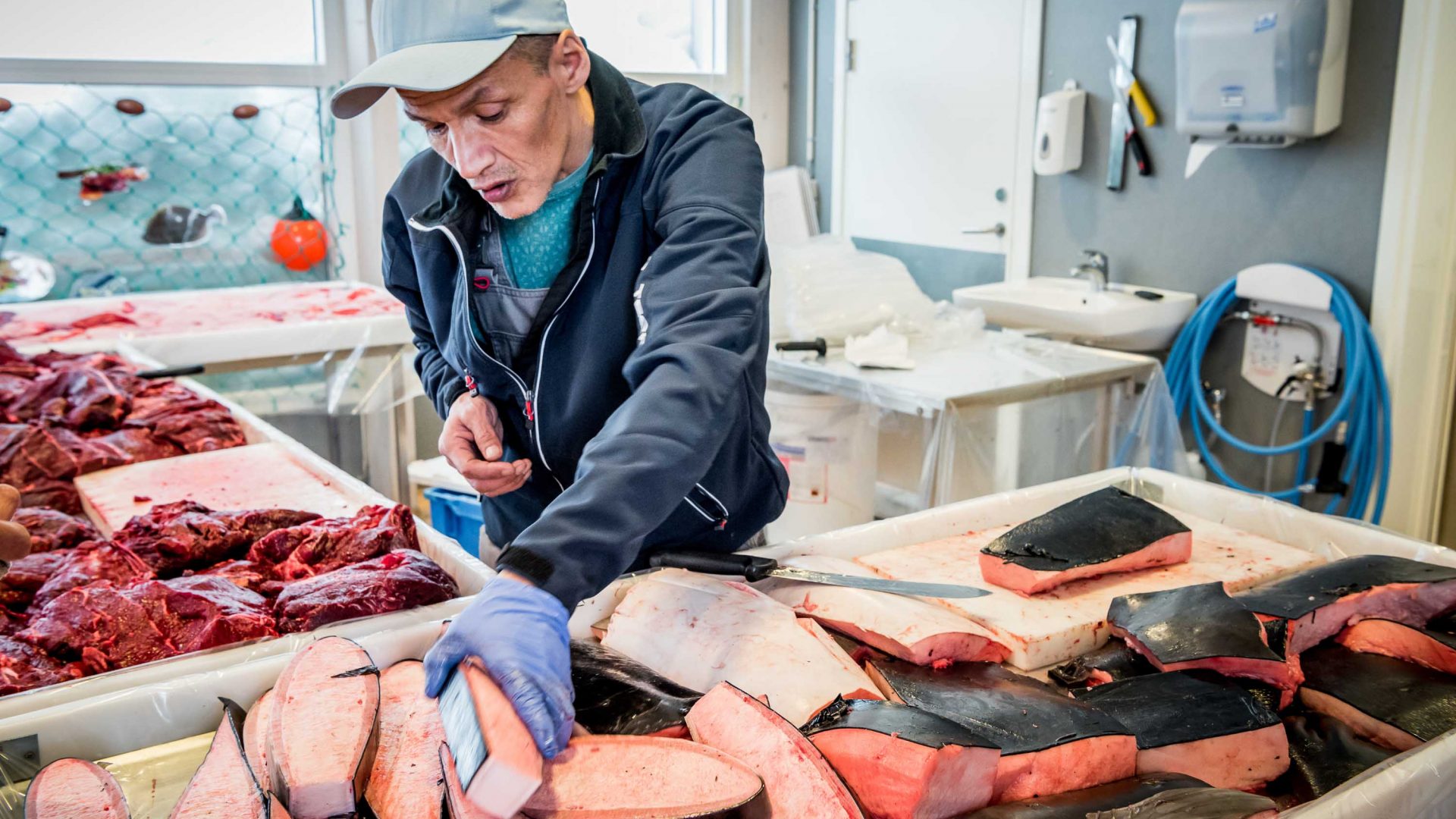 A fishmonger prepares whale blubber for sale at a market in Greenland.