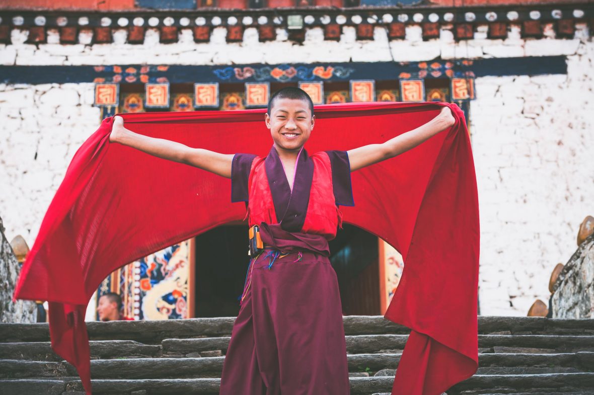 A young novice monk poses for the camera outside the main entrance to Paro’s imposing 15th-century Rinpung Dzong fortress.