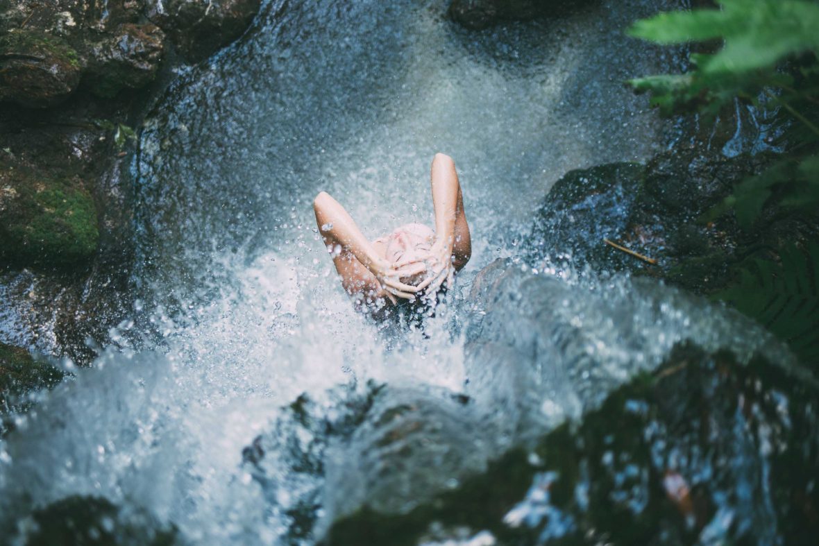 A traveler enjoys the feel of water on their bare skin.