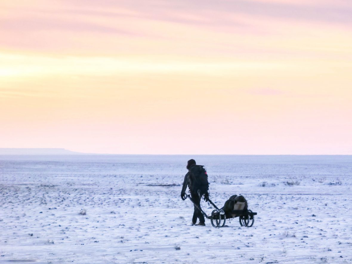 Fellow adventurer Rob Lilwall drags the cart through the snowy wastes of the Gobi Desert.