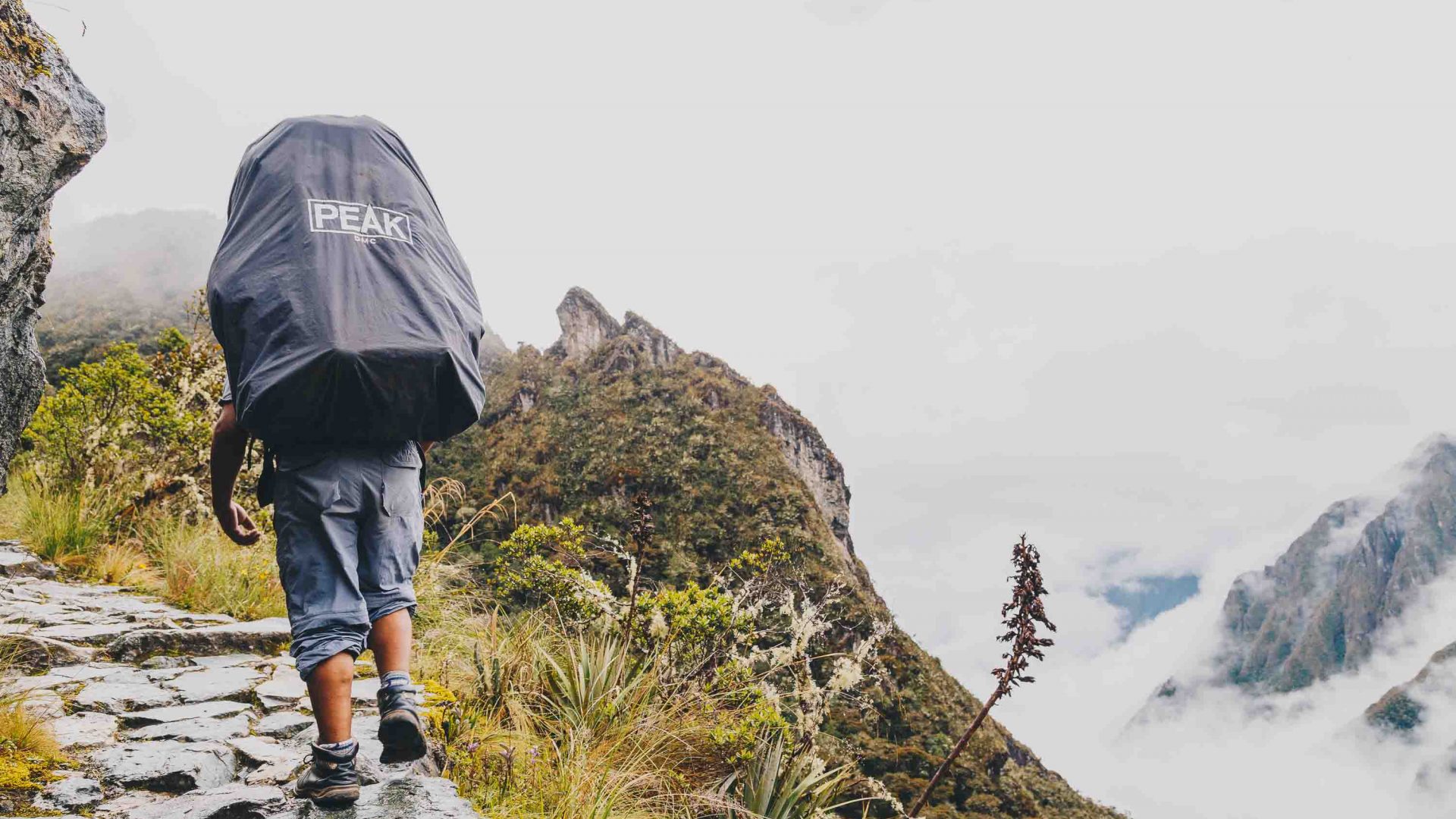 A porter climbs a steep mountain on the Inca Trail, Peru.