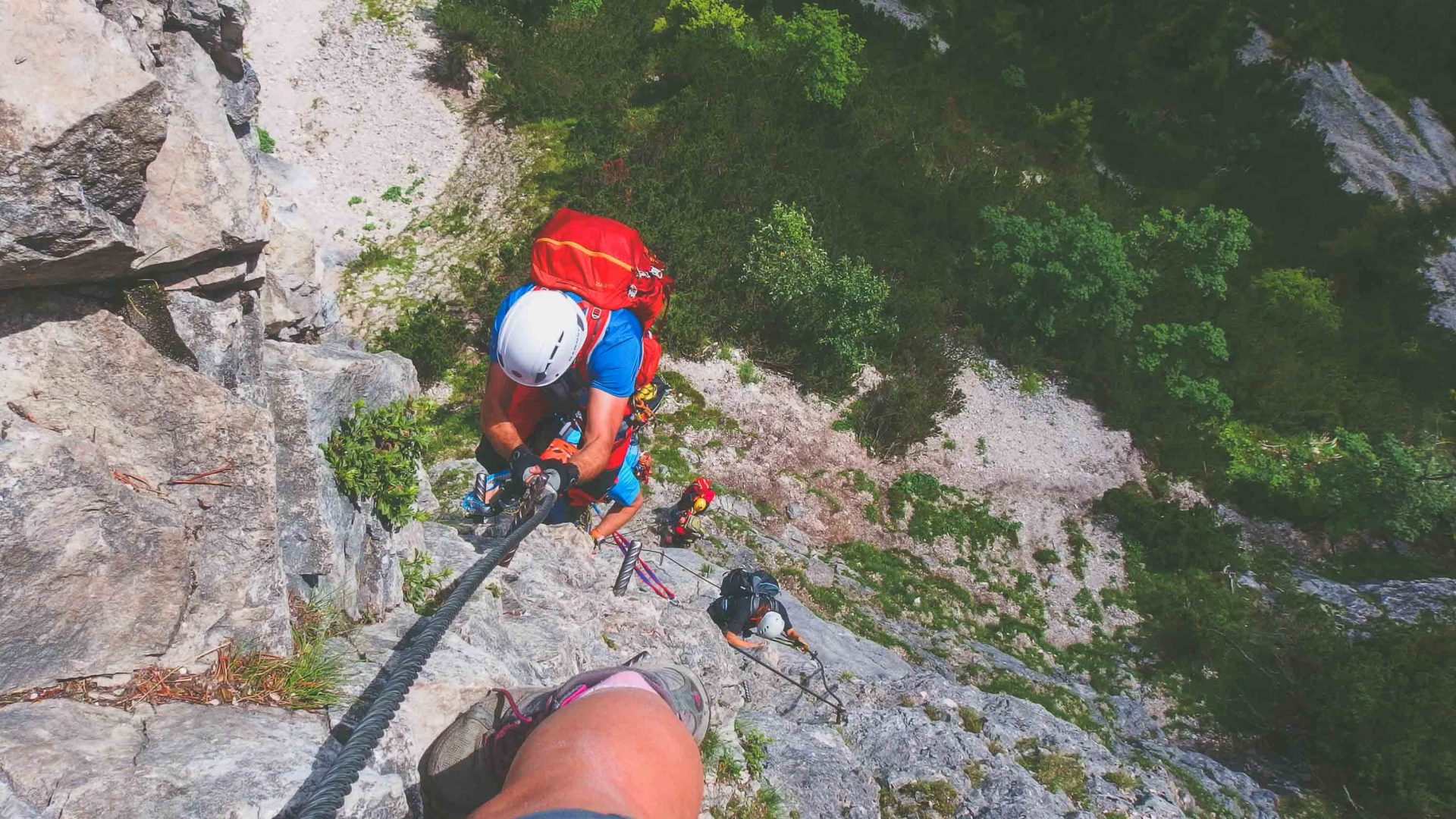 Abseilers take on a steep rock face.