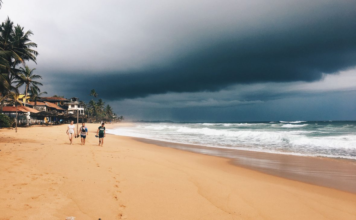 Tourists walk along the beach at Hikkaduwa in Sri Lanka.