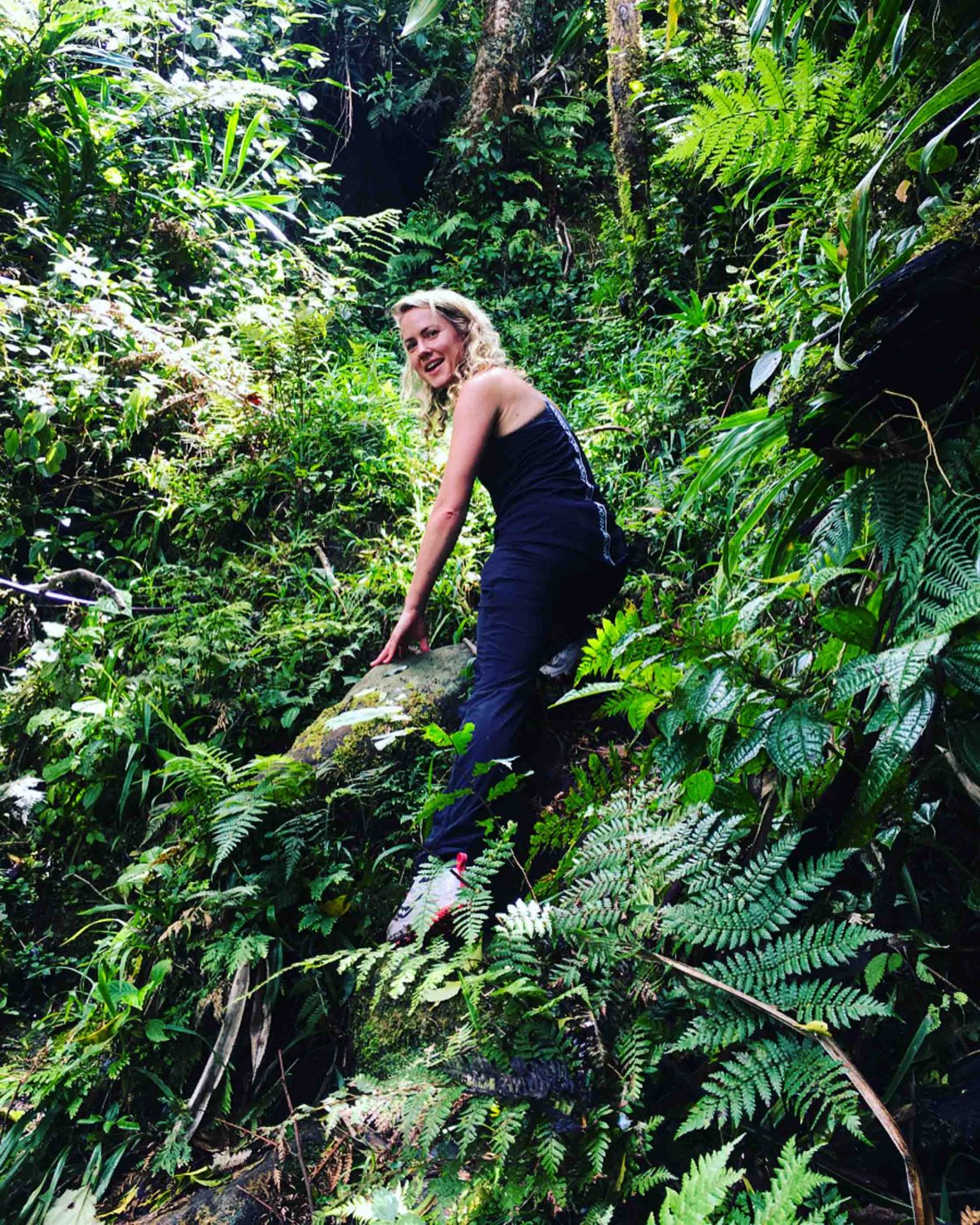 Sadie hiking through rich green forest in Fiji.
