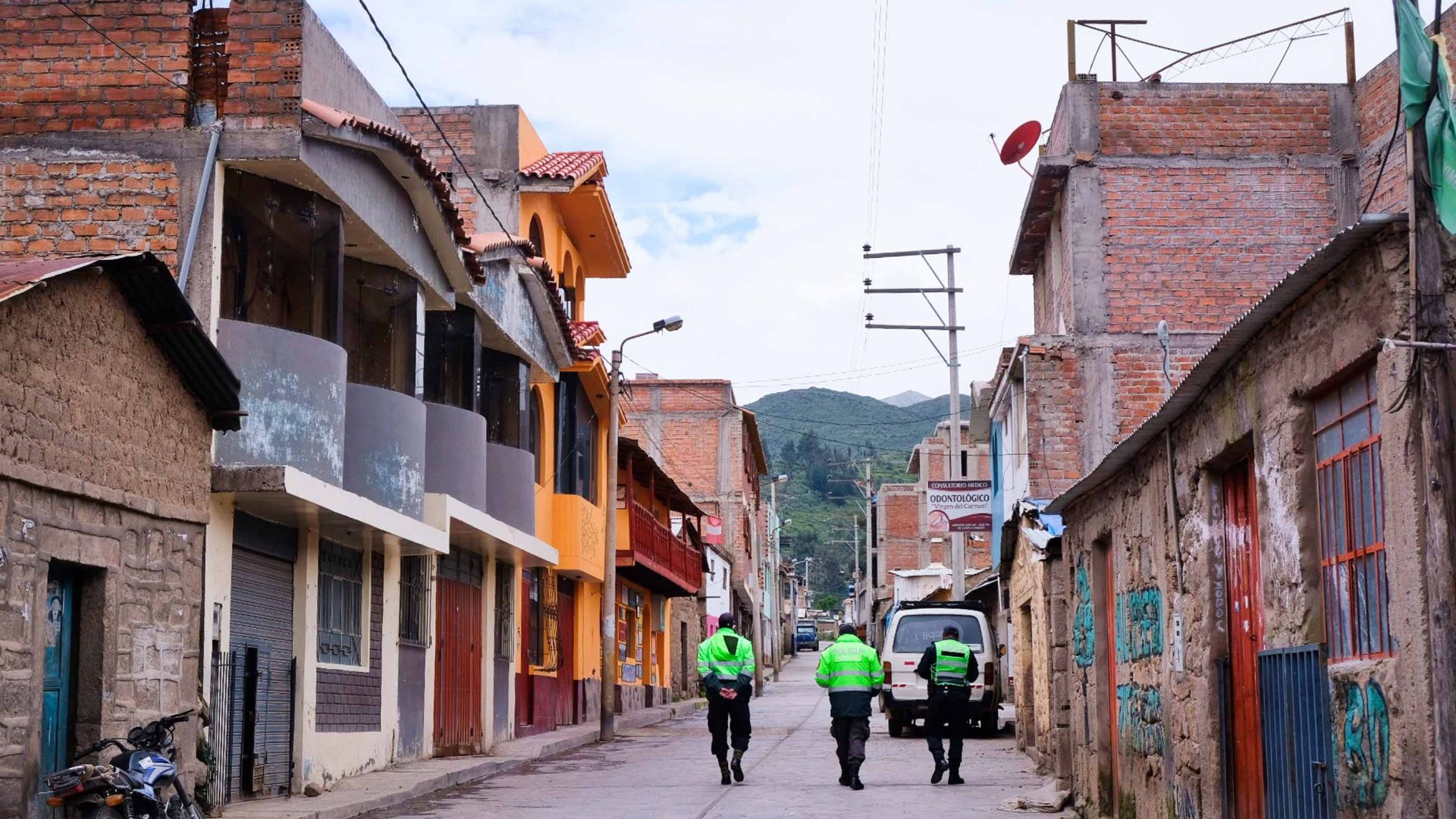 The backs of three police officer in a Peruvian street.