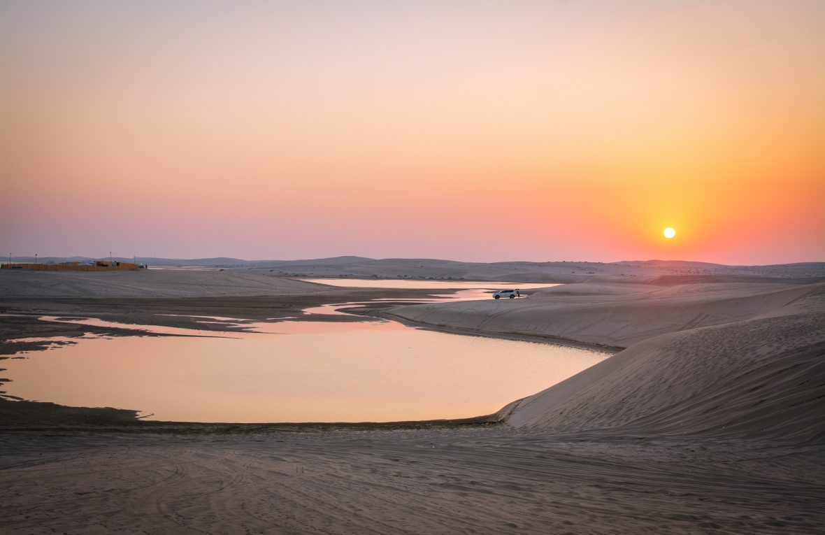 The sun sets over the desert in Qatar.