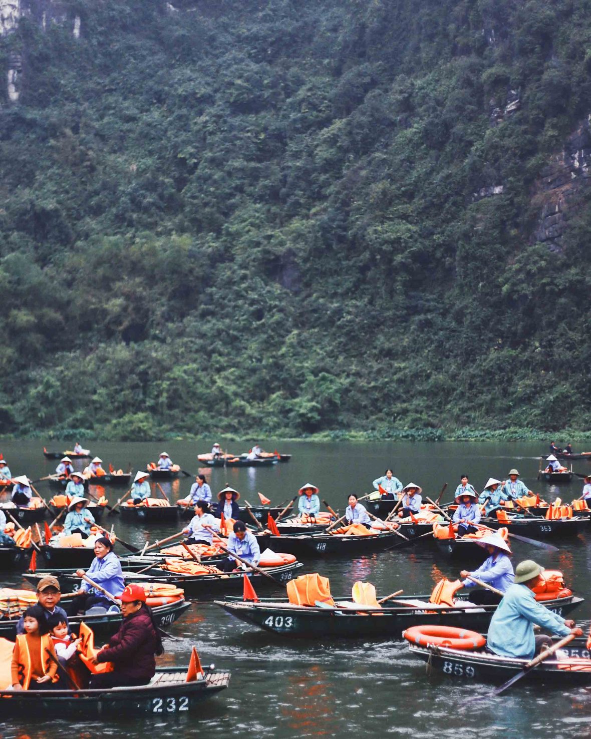 Local Vietnamese tour operators wait for tourists in small row boats in the water.