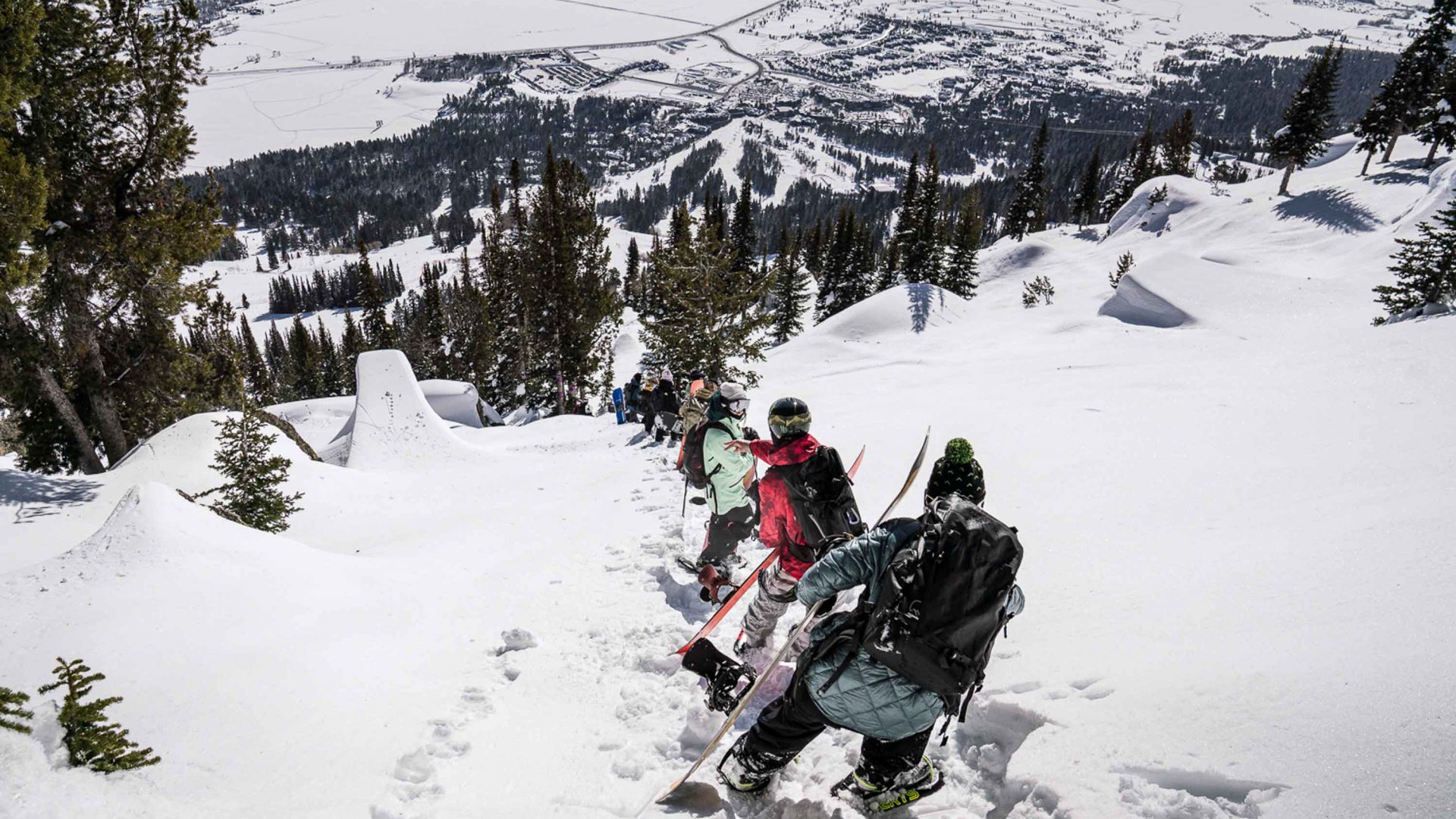 Skiers make their way single file across a hill.