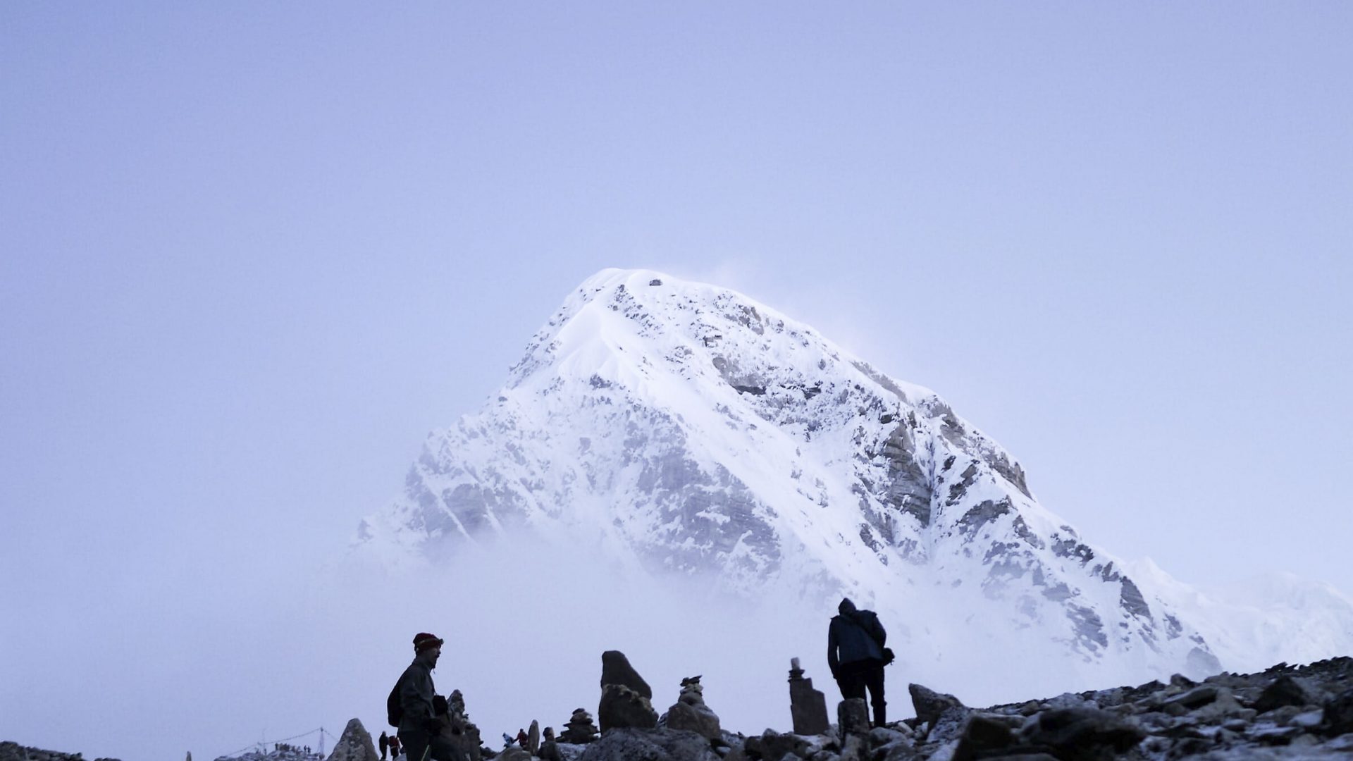 People at Mount Everest Base camp gather to look up at the mountain.