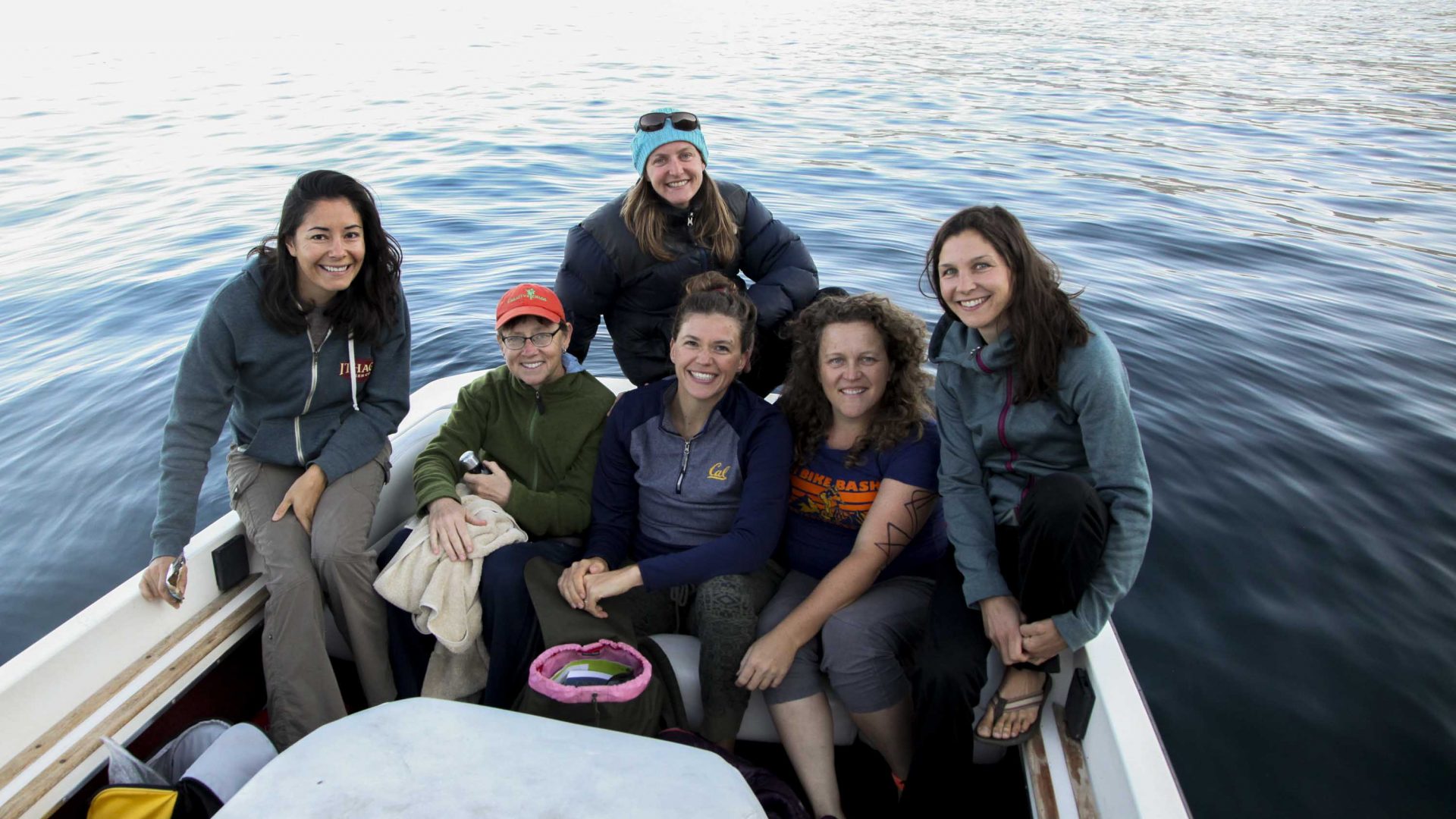 A group of female water quality scientists pose for a photo on a boat.