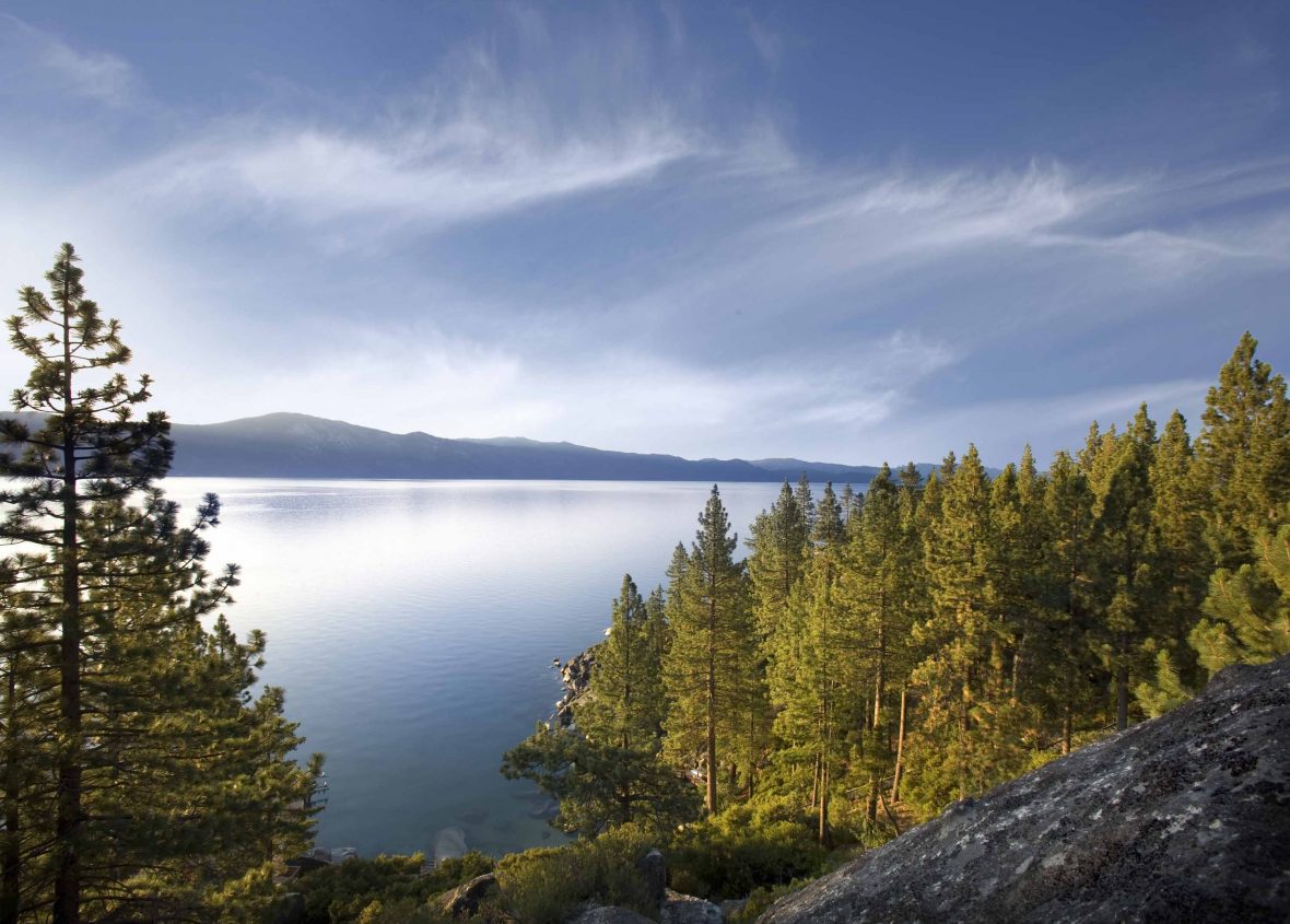The blue waters, greem trees and distant mountains of Lake Tahoe.