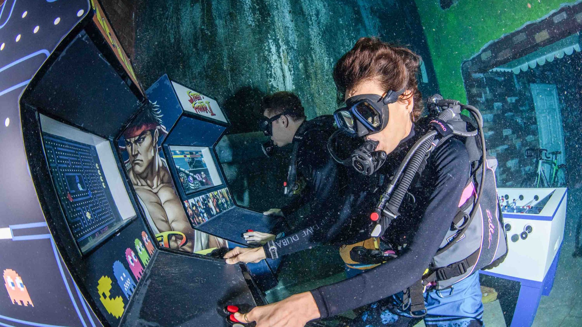 Two divers play an underwater arcade game.