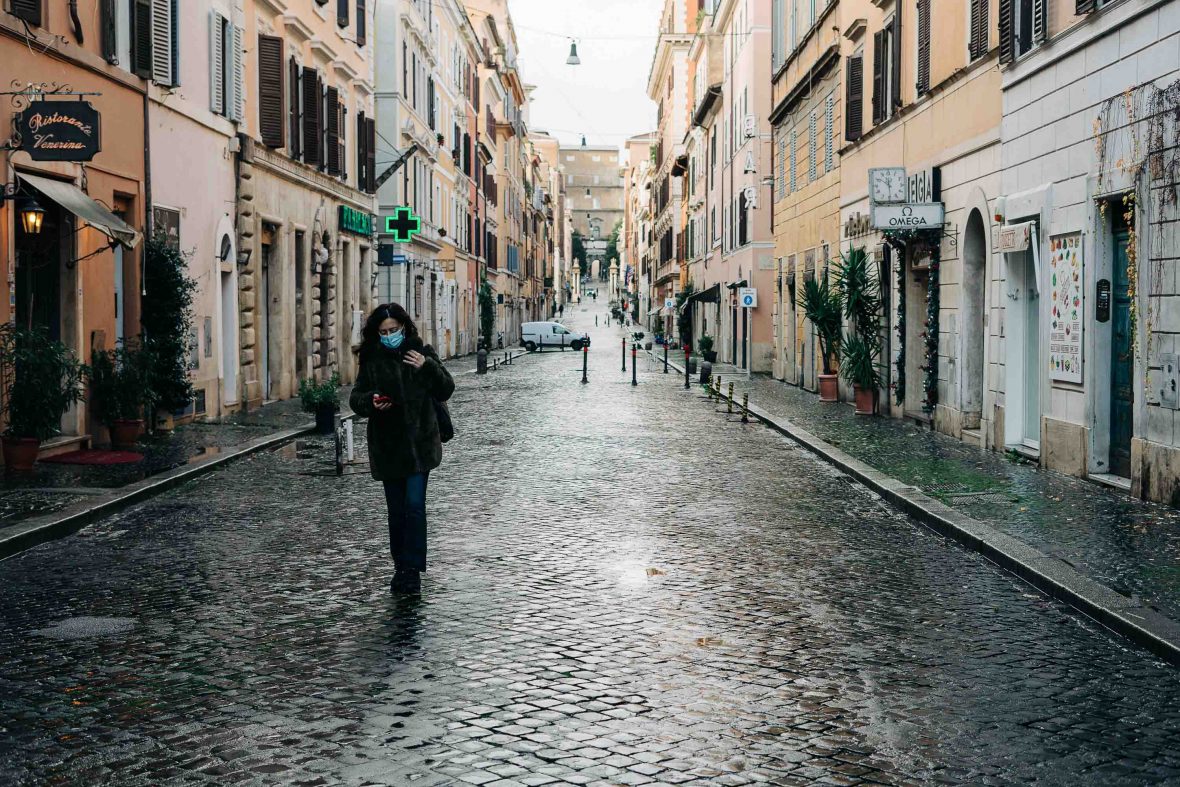 A lone woman in a face mask strolls down an unusually empty street leading up to the Vatican gates during the Covid-19 lockdown in Rome, Italy.