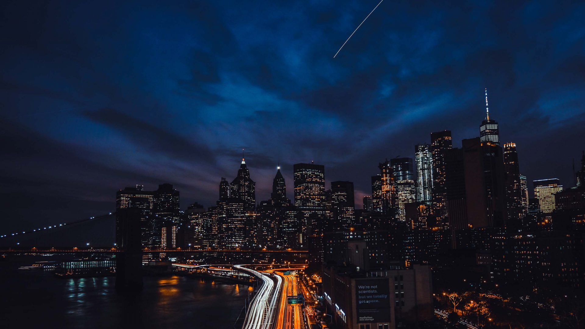 New York City is lit up with lights on buildings and roads at night.