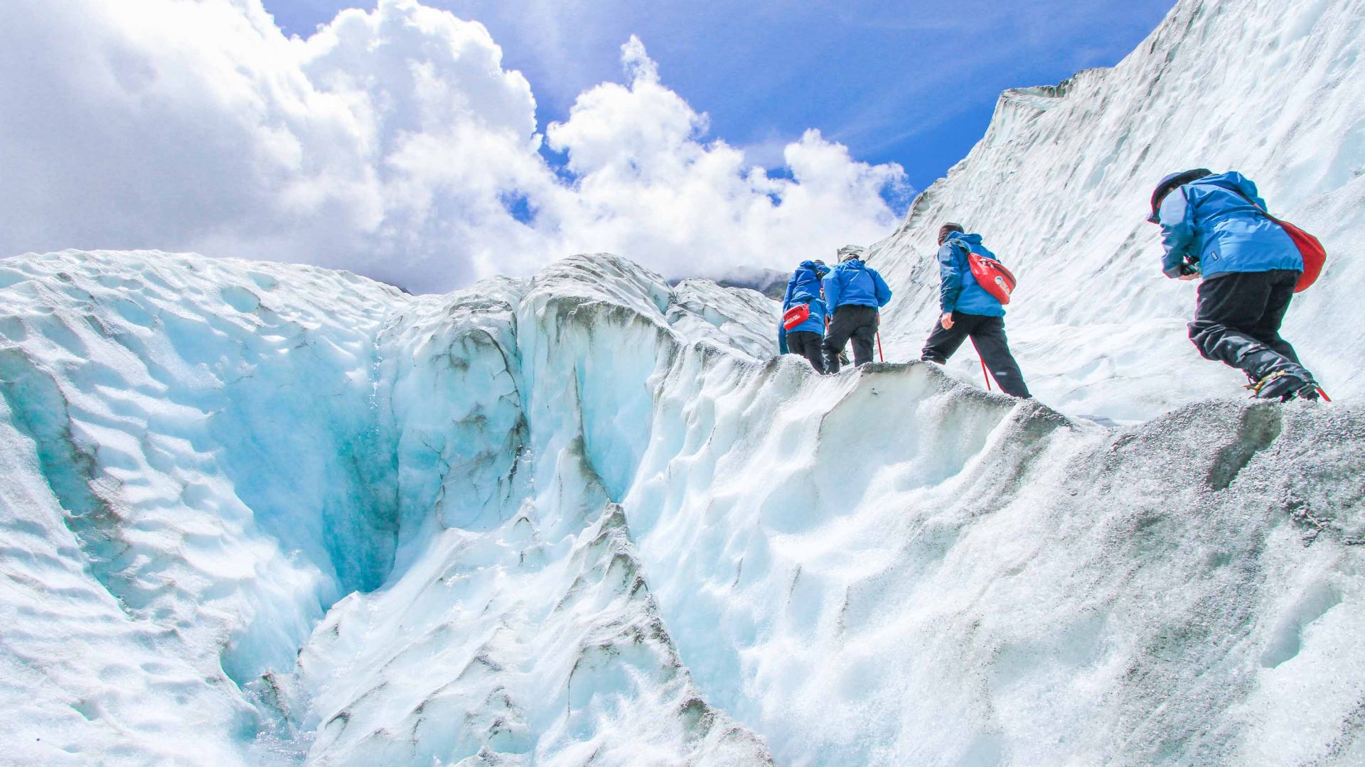 A group climbs up a glacier.