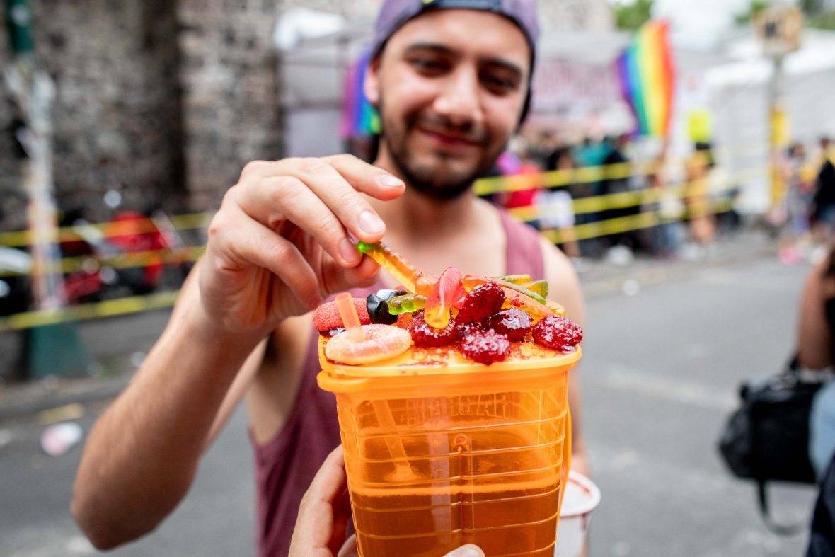 A man goes to pick some candy off the top of a michelada.