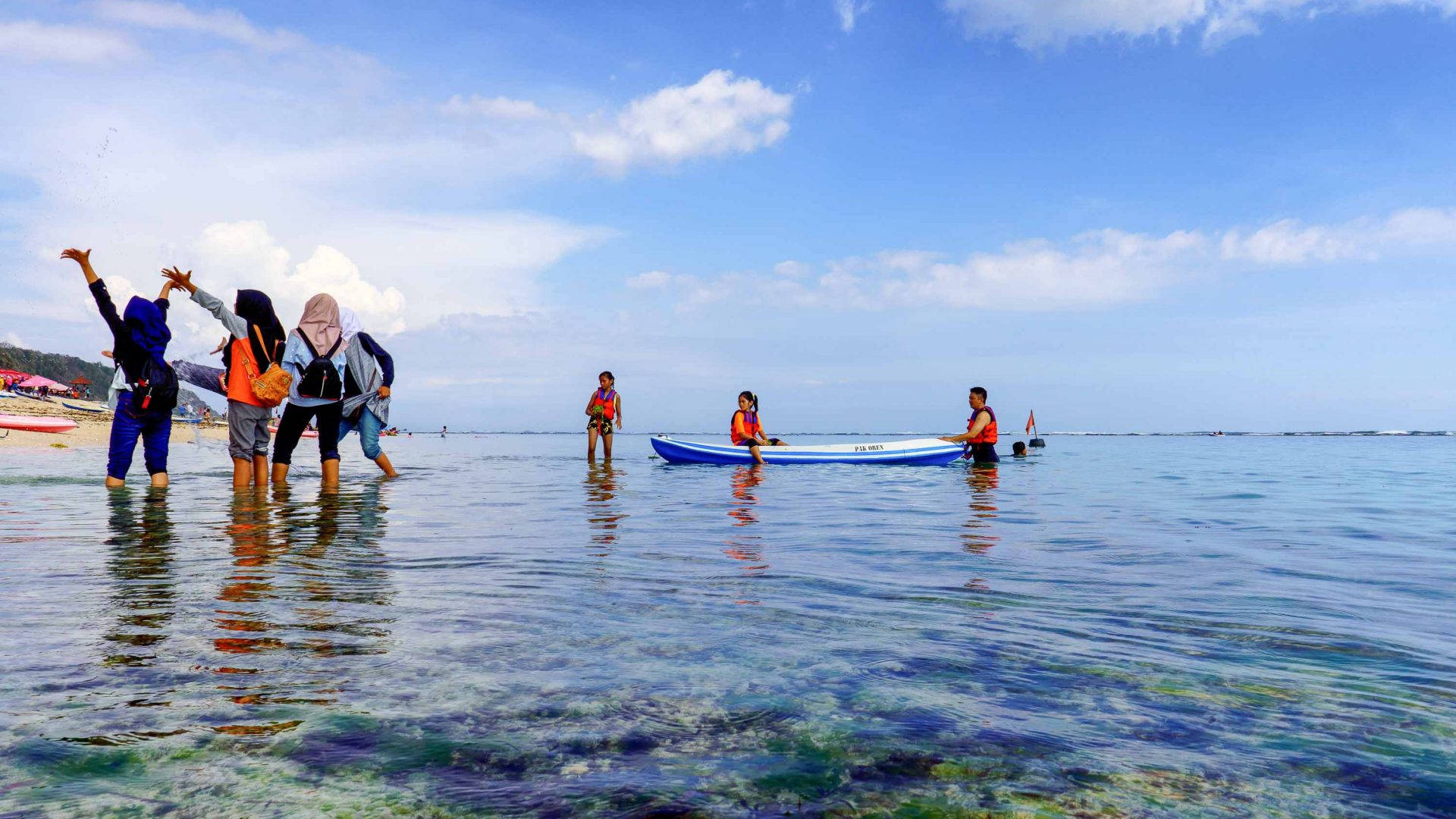People smile for a photo while standing in reef water.