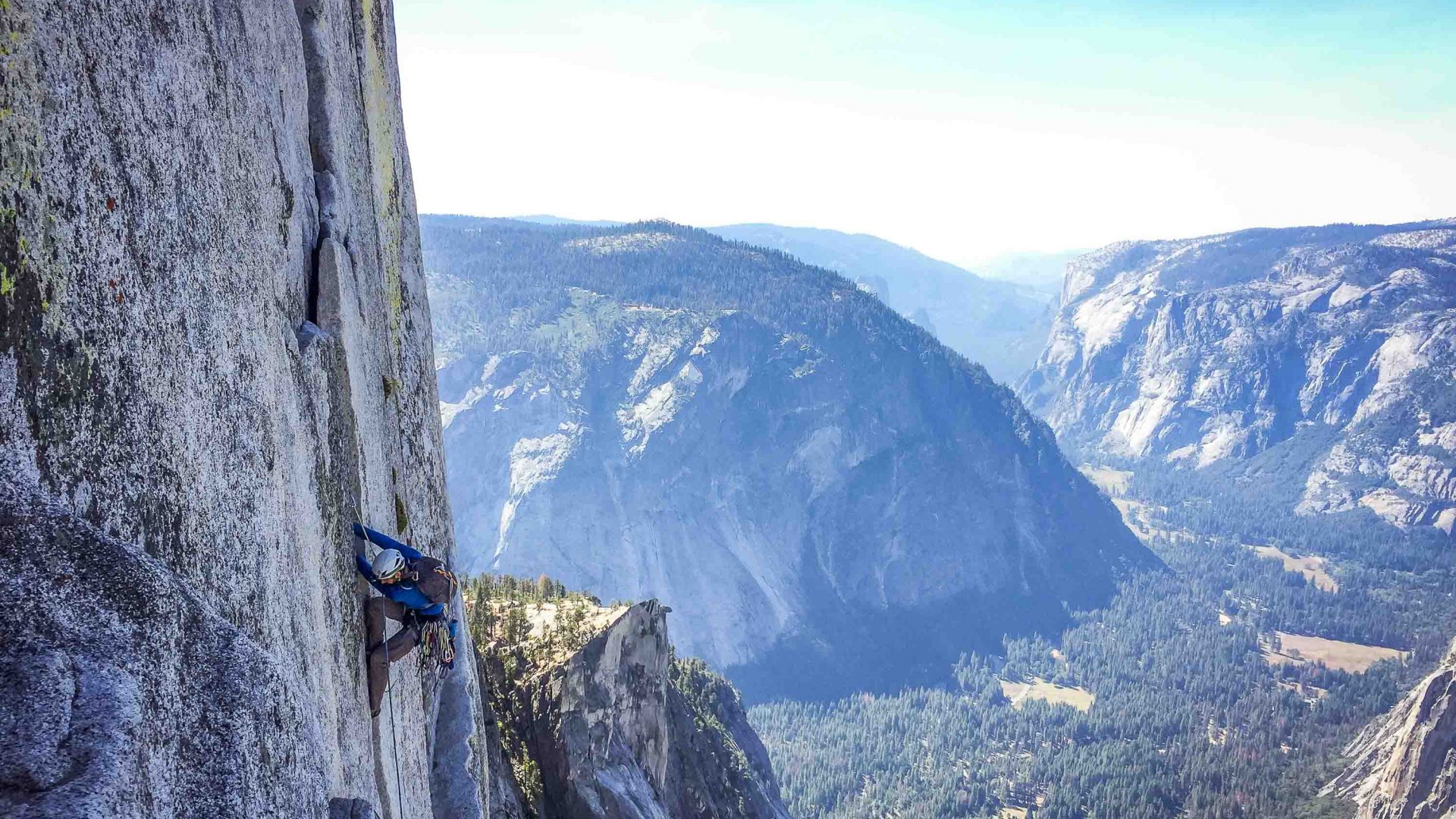 A climber climbing on the edge of a rock face.