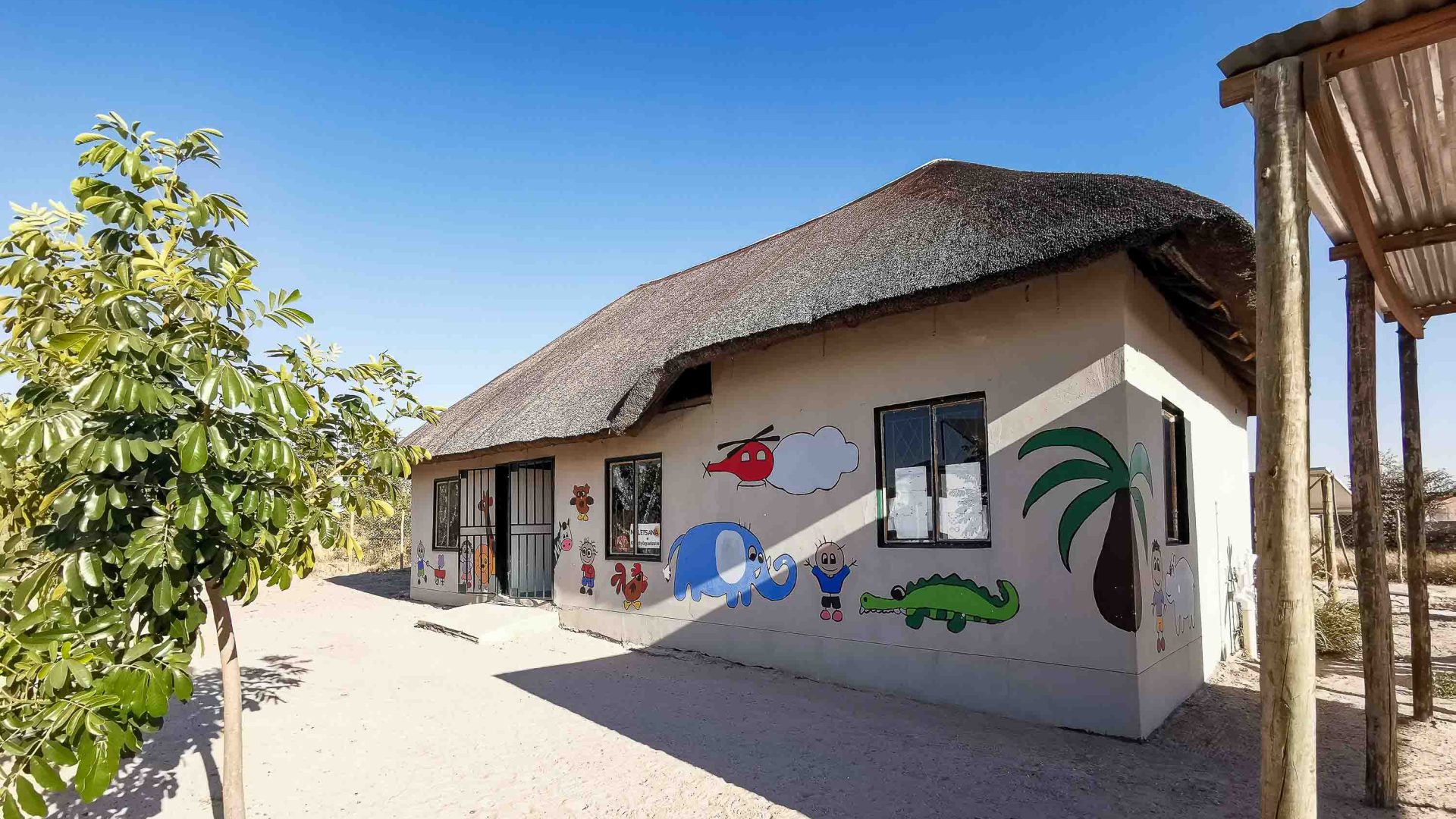Khwai Pre-School with white walls with murals painted on them.