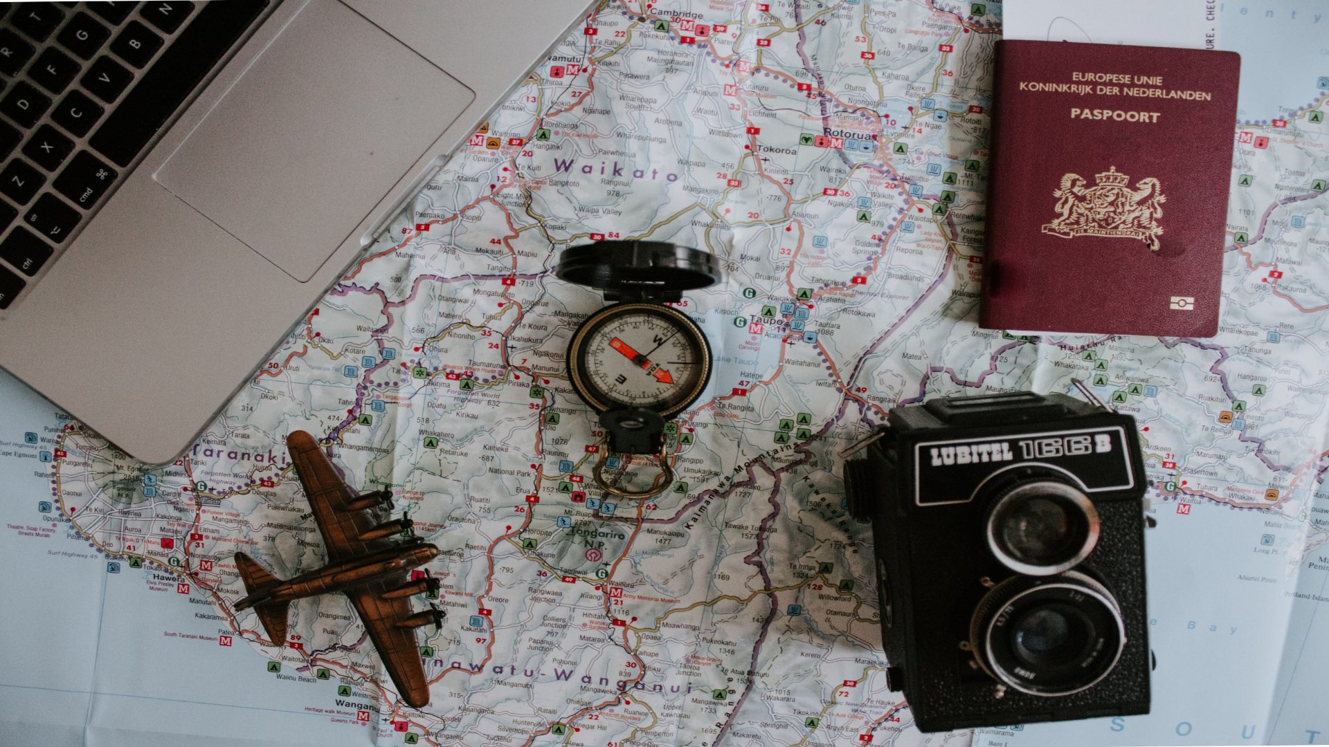 A camera, passport and compass on a map.