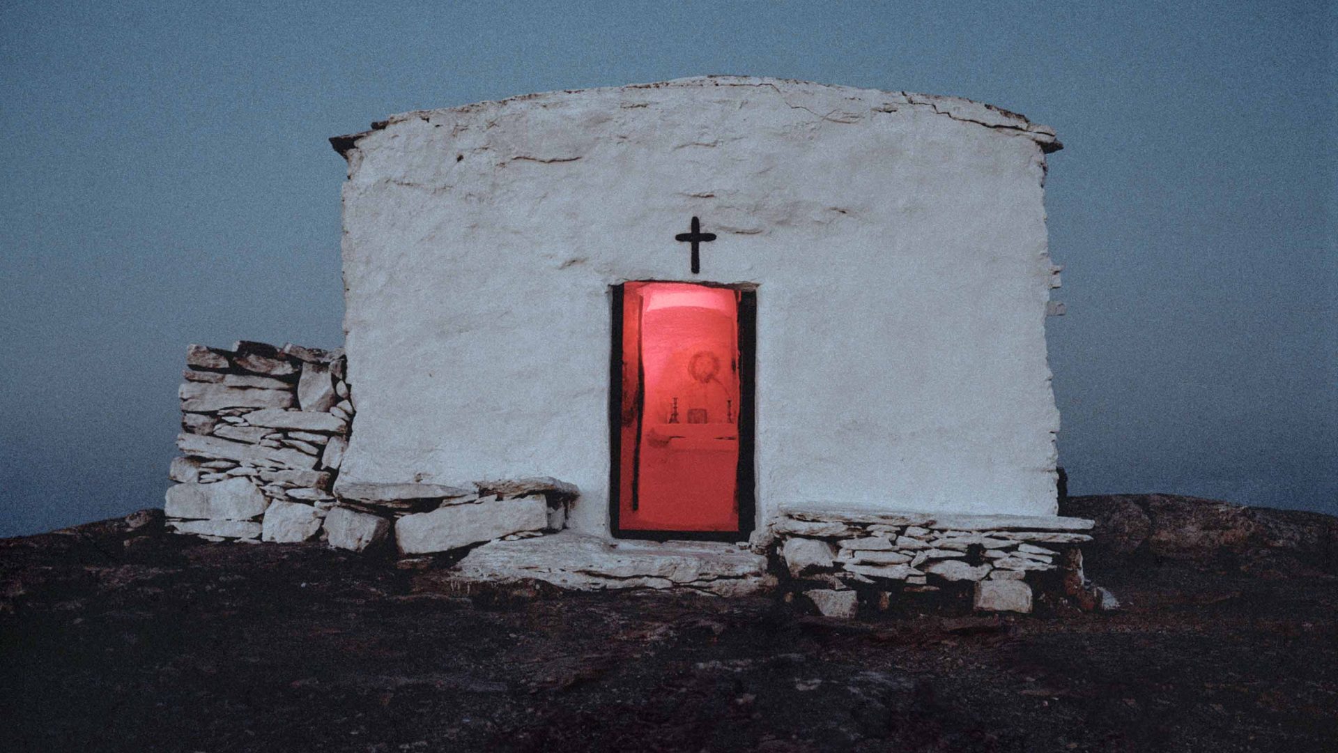 A white church with a glowing red door.